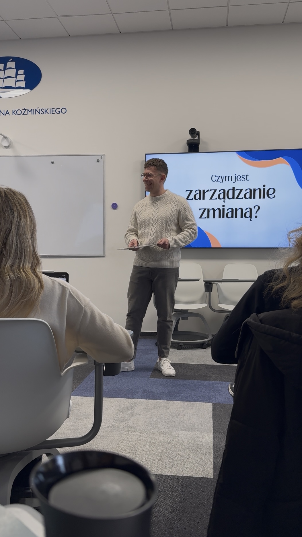 Michał podczas zajęć w Akademii Leona Koźmińskiego, przy ekranie z tematem zarządzania zmianą
